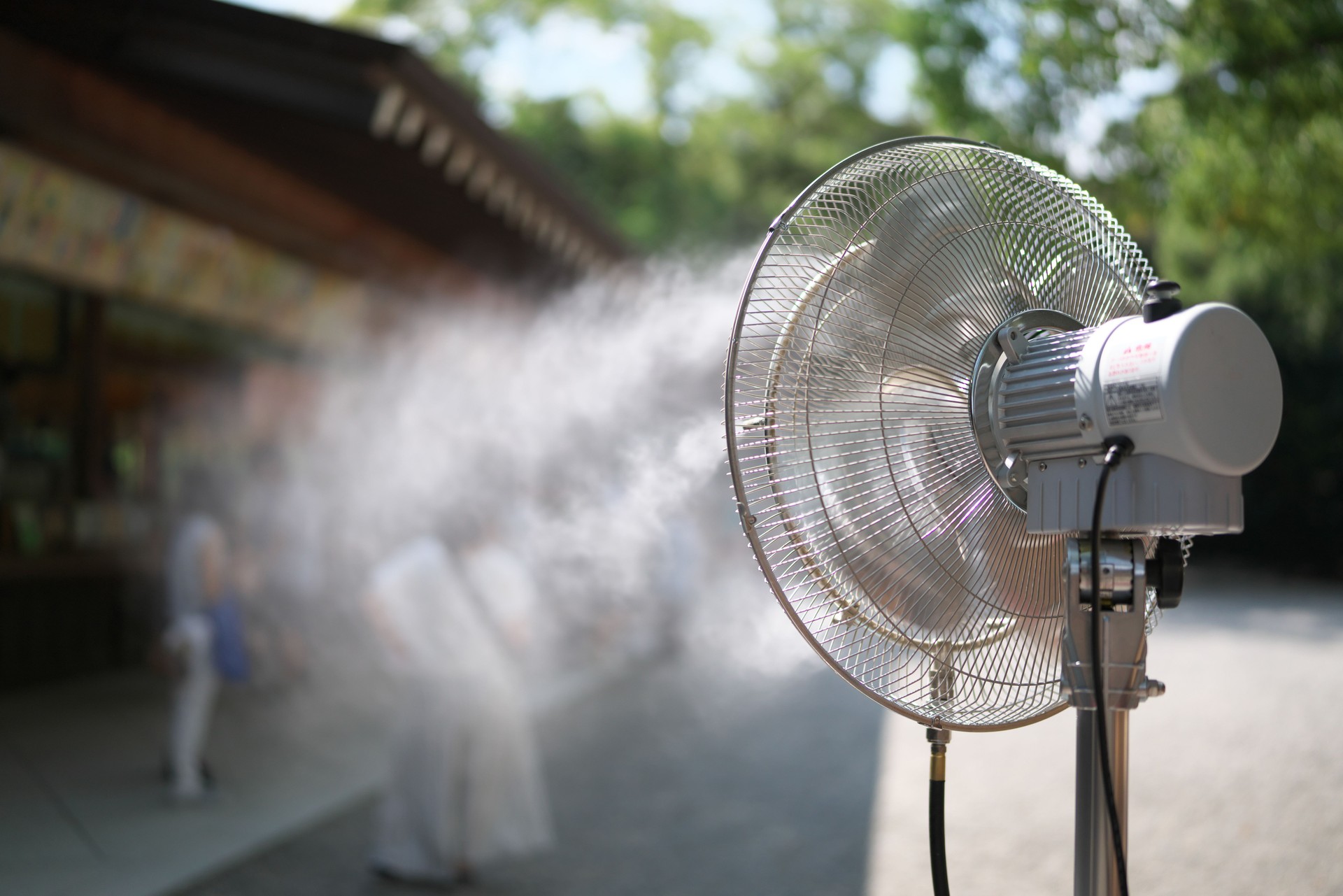 A mist fan operating to cool people visiting a souvenior shop on a hot summer day